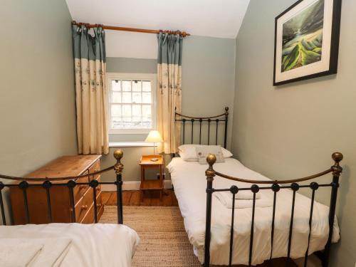 ein Schlafzimmer mit zwei Betten und einem Fenster in der Unterkunft Ednas Cottage in Ambleside