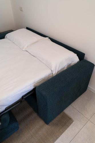 a bed with a black frame in a room at Bilocale Gelsomino - Cascina Da Rosa in Capiago Intimiano