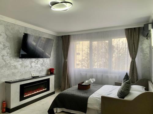 a bedroom with a fireplace and a tv on the wall at Palas Ultraconfort in Iaşi