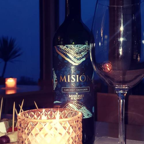 a bottle of wine and a glass on a table at Hotel Nubes de Quinchao in Quinchao