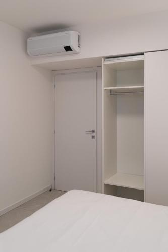 a white room with a door and a closet at Bilocale Gelsomino - Cascina Da Rosa in Capiago Intimiano