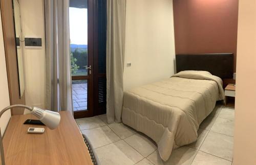 a bedroom with a bed and a table with a lamp at Il Giardino della Torre in Torre Maggiore