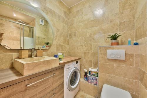 une salle de bain avec une machine à laver et un lavabo dans l'établissement Superbe T2 - Havre de paix moderne près de La Défense, à Courbevoie