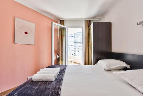 une chambre avec un grand lit et une fenêtre dans l'établissement Superbe T2 - Havre de paix moderne près de La Défense, à Courbevoie