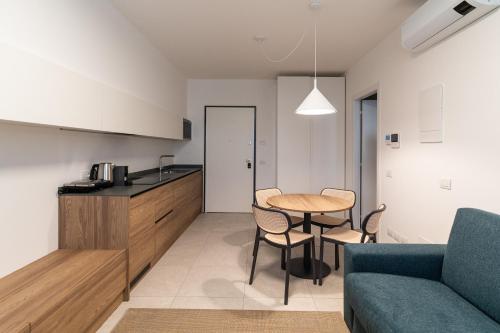 a kitchen and living room with a table and a couch at Bilocale Gelsomino - Cascina Da Rosa in Capiago Intimiano
