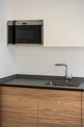 a kitchen with a sink and a microwave at Bilocale Gelsomino - Cascina Da Rosa in Capiago Intimiano