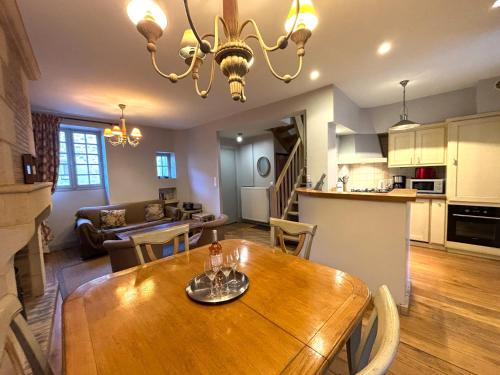 Il comprend une cuisine et un salon avec une table à manger en bois. dans l'établissement Hostelerie du Presidial : 3chbres/3sdb de standing au coeur de la citée de Sarlat, à Sarlat-la-Canéda