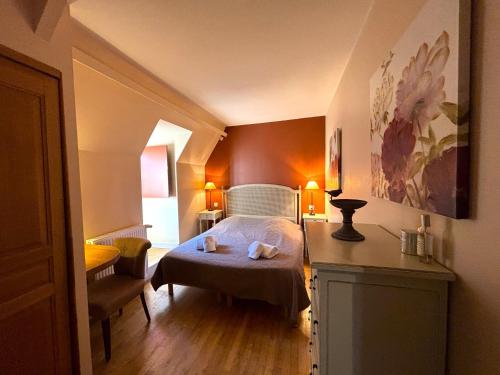 une chambre avec un lit et une chaise dans une pièce dans l'établissement Hostelerie du Presidial : 3chbres/3sdb de standing au coeur de la citée de Sarlat, à Sarlat-la-Canéda