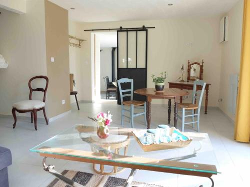 un salon avec une table et des chaises dans l'établissement Gite à la campagne, à Villedômer