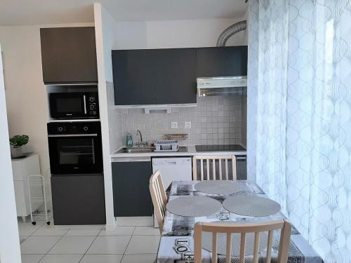 une cuisine avec une table et des chaises ainsi qu'une cuisine avec une table et des chaises dans l'établissement Le Penfoul - port et bourg à pied, à Bénodet