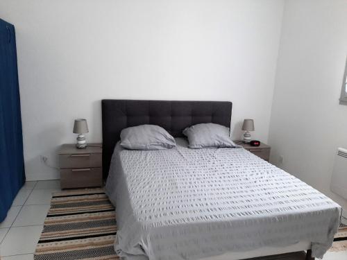 une chambre avec un grand lit avec deux tables de nuit dans l'établissement Le Penfoul - port et bourg à pied, à Bénodet