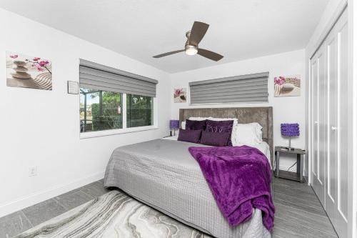 a bedroom with a bed with a purple blanket at Villa Tranquility-Waterfront-Punta Gorda, FL in Punta Gorda