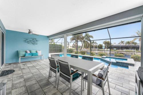 a dining room with a table and chairs and a pool at Villa Tranquility-Waterfront-Punta Gorda, FL in Punta Gorda