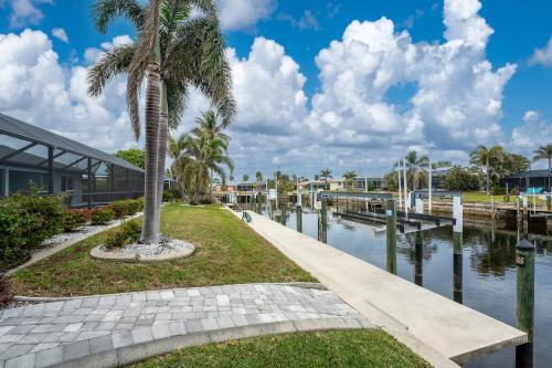 a palm tree next to a canal with a building at Villa Tranquility-Waterfront-Punta Gorda, FL in Punta Gorda