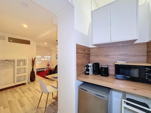 une cuisine avec des placards blancs et un comptoir avec un four micro-ondes dans l'établissement Victor Fort - My Cinéma, Lyon Croix Rousse, à Lyon