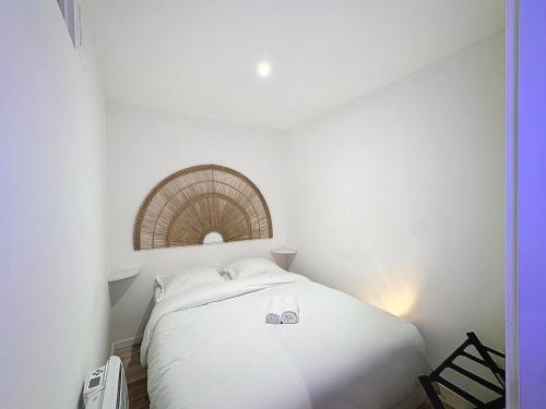 - une chambre dotée d'un lit blanc avec deux chaussures dans l'établissement Victor Fort - My Cinéma, Lyon Croix Rousse, à Lyon