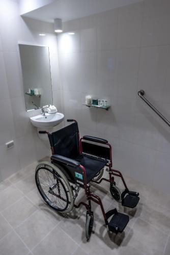 a wheelchair sitting in a bathroom with a sink at Lithgow Workies Club Motel in Lithgow