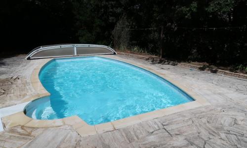 une piscine avec de l'eau bleue dans une cour dans l'établissement Piscine, villa architecte, vue exceptionnelle, à Saint-Georges-les-Bains
