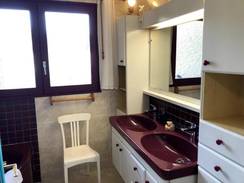 La salle de bains est pourvue d'un lavabo et d'une chaise. dans l'établissement Piscine, villa architecte, vue exceptionnelle, à Saint-Georges-les-Bains