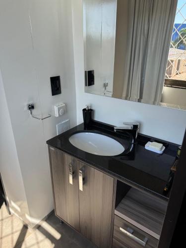 a bathroom with a sink and a mirror at Prédio Green Hall in Toledo