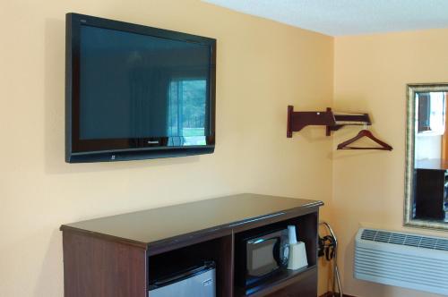 a flat screen tv hanging on a wall at Budgetel Inn Glens Falls-Lake George-Saratoga in Glens Falls