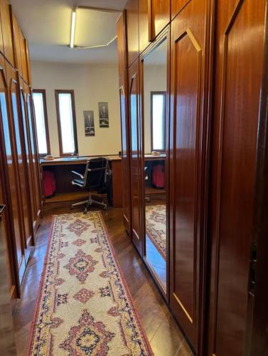 an office with wooden furniture and a rug in a hallway at Linda Suite Master no Jd Marajoara em Casa de Alto Padrão in Sao Paulo