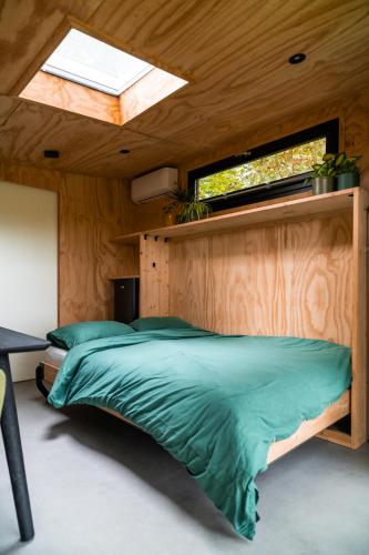 a bedroom with a large bed with a skylight at Boshuisje Zelhem in Zelhem