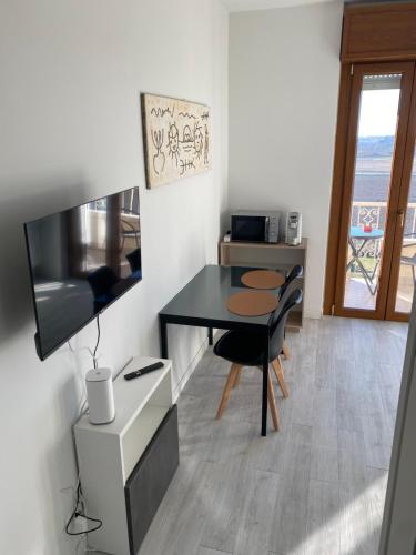 a room with a desk and a table and a television at Appartamento 47 in Novara