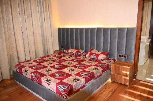 1 dormitorio con 1 cama grande y cabecero gris en Aayaan Roy villa, en Manali