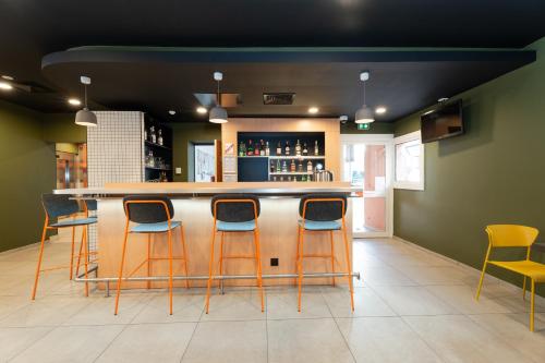a bar with four stools in a room at easyHotel Nice Old Town in Nice