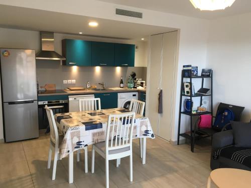 une cuisine avec une table et des chaises dans une pièce dans l'établissement 2 Terrasses entre Mer et Montagne T2 de 52m2 avec Wifi, à Port-Vendres