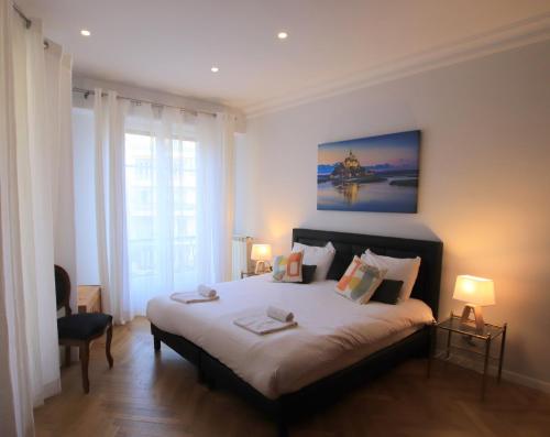 une chambre avec un grand lit et une grande fenêtre dans l'établissement La Suite Liberation, à Nice