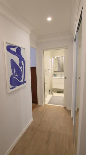 un couloir avec une salle de bains et une peinture murale. dans l'établissement La Suite Liberation, à Nice