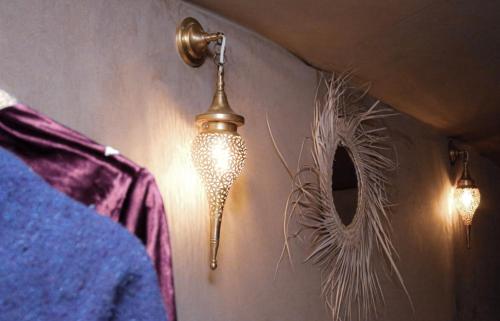 a lamp hanging on a wall next to a mirror at Alicante Luxury Camp Merzouga in Merzouga