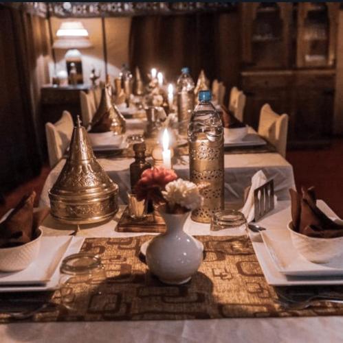 a long table with white plates and vases on it at Alicante Luxury Camp Merzouga in Merzouga