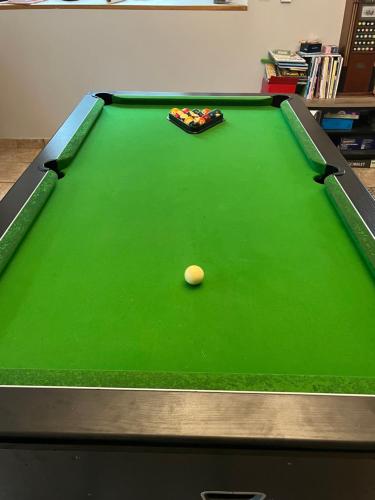 a green felt pool table with a ball on it at Le Blockhaus de Domléger et Spa in Domléger