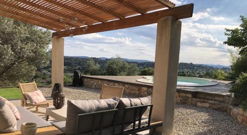 une terrasse avec une pergola et une piscine dans l'établissement Villa de Charme magnifique vue Panoramique et Piscine, à Lorgues