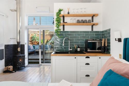 a kitchen with a sink and a stove at 5 min walk to beach with parking and private sauna in Falmouth