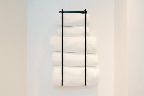a stack of white towels on a rack at 5 min walk to beach with parking and private sauna in Falmouth