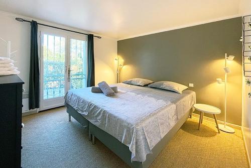 une chambre avec un lit et une grande fenêtre dans l'établissement VILLA CHEZ-NOUS C'est chez vous, piscine, plages et golfs, à Saint-Raphaël