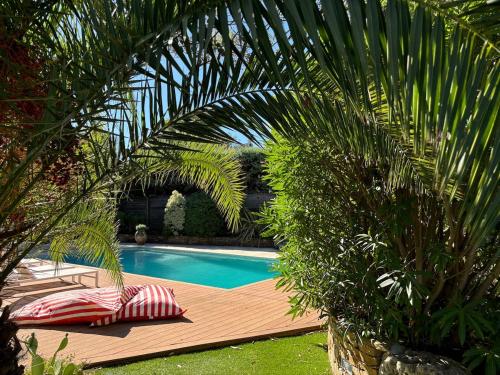 - une piscine avec deux oreillers sur une terrasse en bois dans l'établissement VILLA CHEZ-NOUS C'est chez vous, piscine, plages et golfs, à Saint-Raphaël
