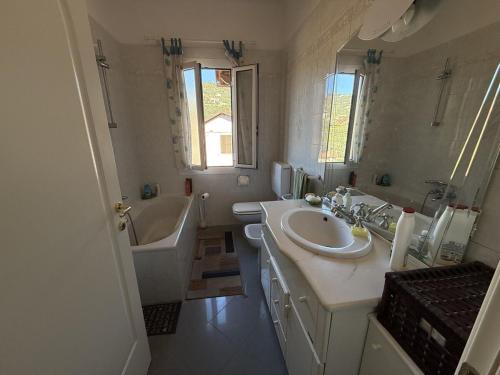 y baño con lavabo, bañera, aseo y espejo. en The Piano Apartment - Beautiful View - by Host4U, en Imperia