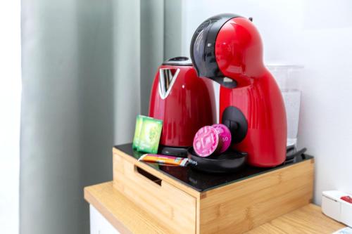 une cafetière rouge assise au-dessus d'un comptoir dans l'établissement Studio cosy 2P - Proche Versailles/Paris, à Le Chesnay
