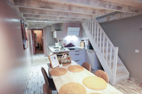 une cuisine et une salle à manger avec une table et un escalier dans l'établissement Résidence Les Bergamottes, à Thônes