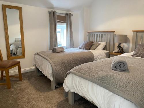 a bedroom with two beds and a mirror at Idyllic Two bed country cottage in Kirkby Thore