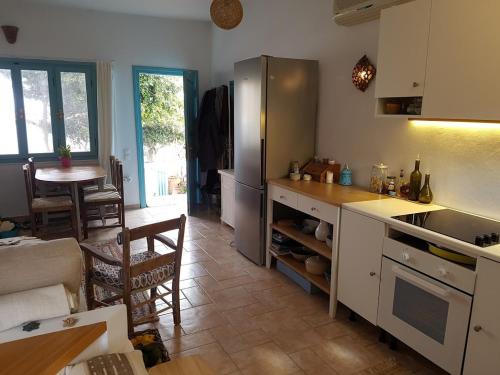 a kitchen with a refrigerator and a table and a table at Mochlos Beach Villa Seafront house in Mochlos
