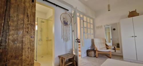 a bathroom with a walk in shower and a chair at Mochlos Beach Villa Seafront house in Mochlos