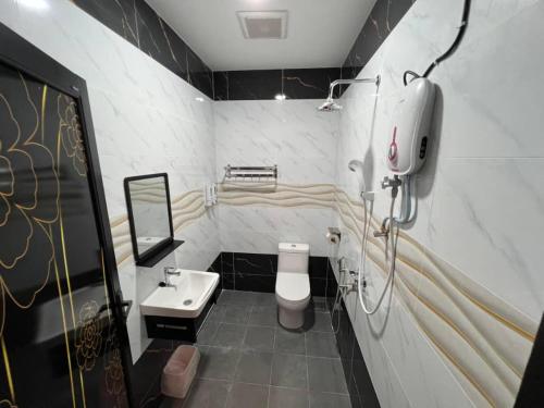 Un baño con un inodoro blanco y un lavabo. en MY QALBU Beach Inn, en Kampong Sura Masjid
