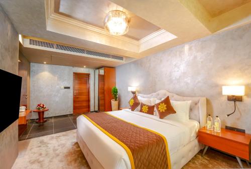 a bedroom with a large bed in a room at Jardin Hotels Teen Imli in Indore