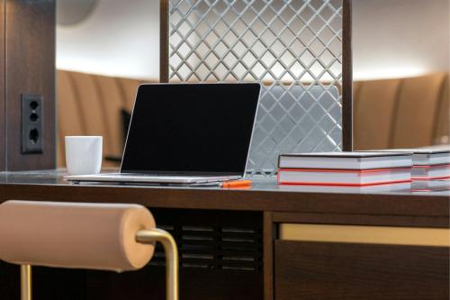 a laptop computer sitting on a desk with books at Neues Schloss Privat Hotel Zurich, Autograph Collection in Zürich